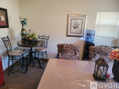 A living room with a couch, chair, table, and vase.