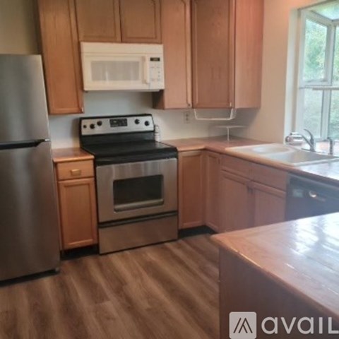 A kitchen with wooden cabinets and a stainless steel refrigerator.