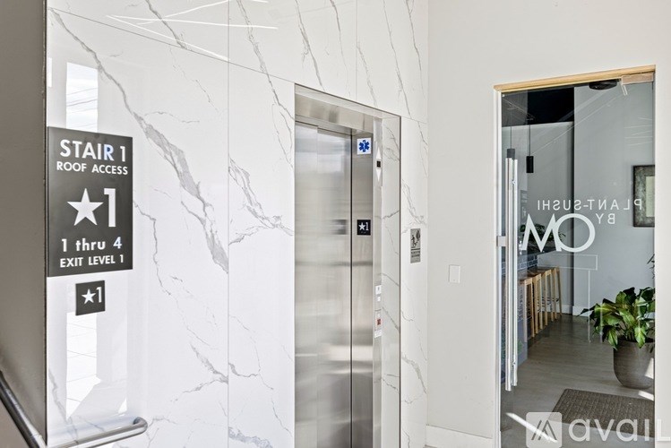 A stairwell with a sign that says "Stair 1 Roof Access" and "1 thru 4 Exit Level 1".