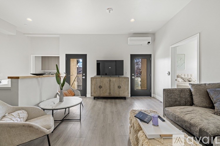 A living room with a sofa, a chair, a coffee table, and a television.