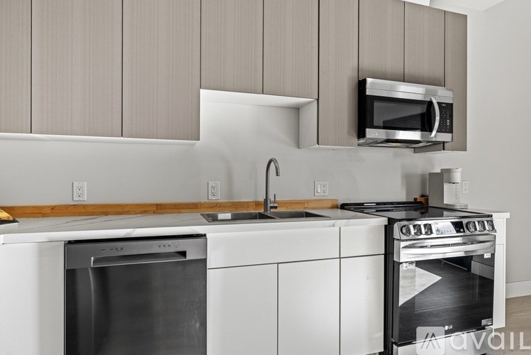 A modern kitchen with white appliances and wooden cabinets.
