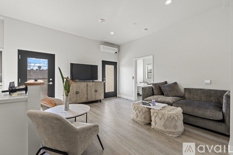 A living room with a grey couch, a white chair, and a television.