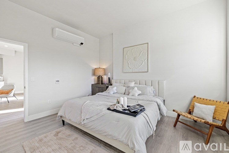 A bedroom with a large bed and a wooden chair.