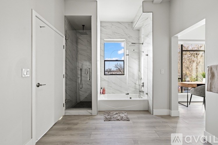 A bathroom with a marble shower and a window.