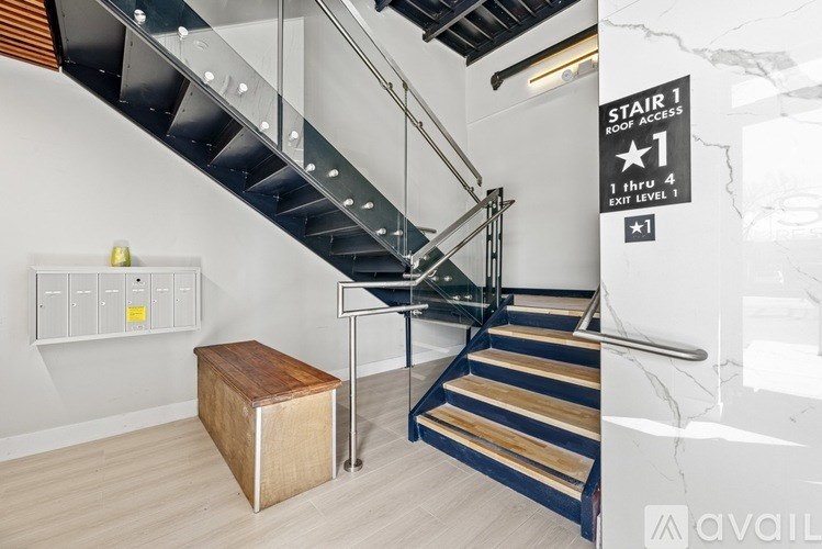 A staircase with a sign that says "STAIR 1 ROOF ACCESS" and "1 THRU 4 EXIT LEVEL 1".