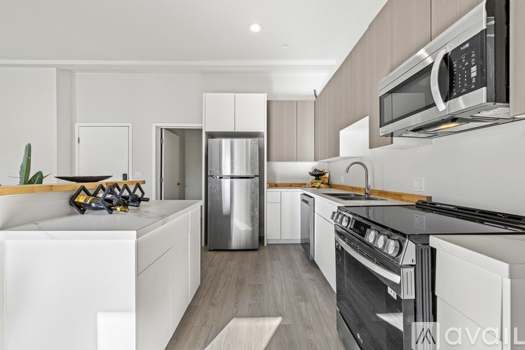 A modern kitchen with white cabinets and stainless steel appliances.