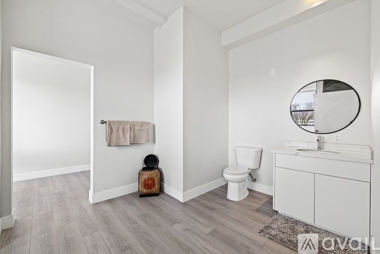 A bathroom with a toilet, sink, and mirror.