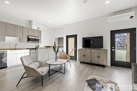 A modern living room with a chair, a table, and a cabinet.