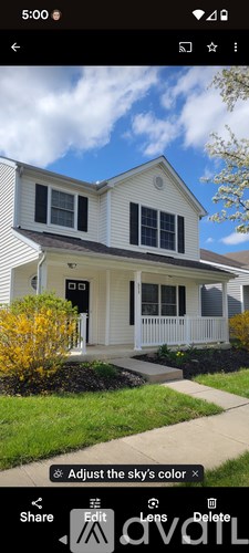 A white house with a black door and windows is shown.