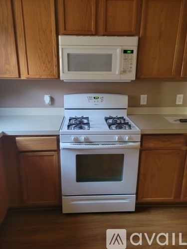 A white stove and oven in a kitchen with wooden cabinets.