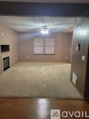 A room with a carpet floor and a fireplace.