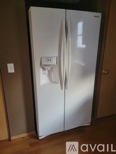 A white fridge with a water and ice dispenser built in.