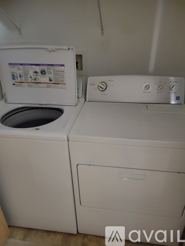 A white washing machine with a door and a control panel.
