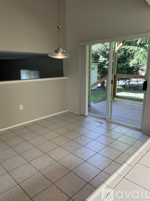 A room with a tiled floor and a sliding glass door leading to a backyard.