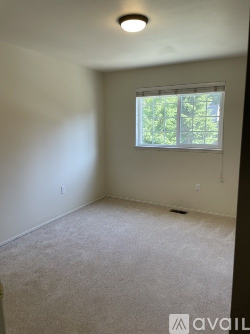 A room with a window and carpeted floor.