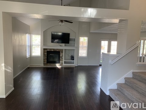 A living room with a fireplace and a television mounted on the wall.
