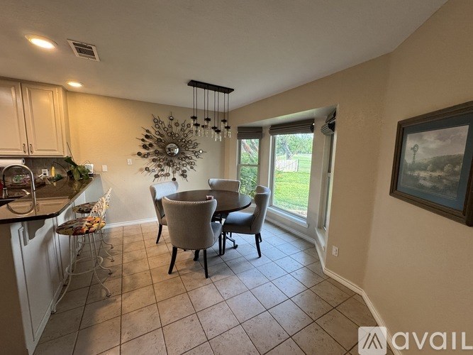 A kitchen with a dining table and chairs.
