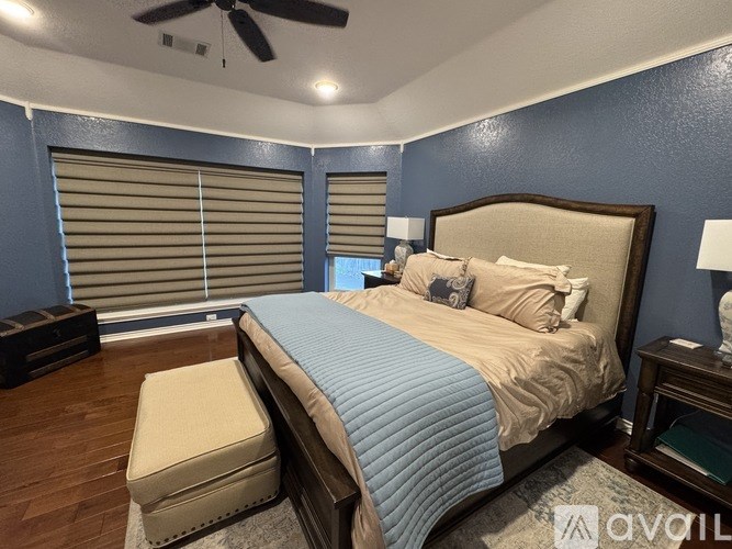 A bedroom with a bed, nightstand, and window with blinds.
