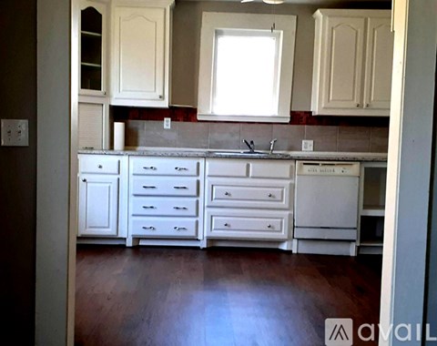 A kitchen with white cabinets and drawers.