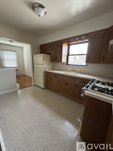 A kitchen with wooden cabinets and a white fridge.