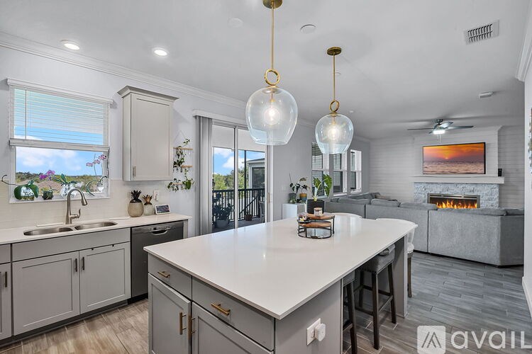 A modern kitchen with a large island and pendant lights.
