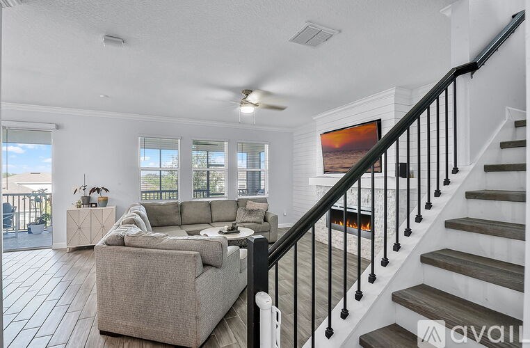A living room with a couch, a chair, and a painting on the wall.