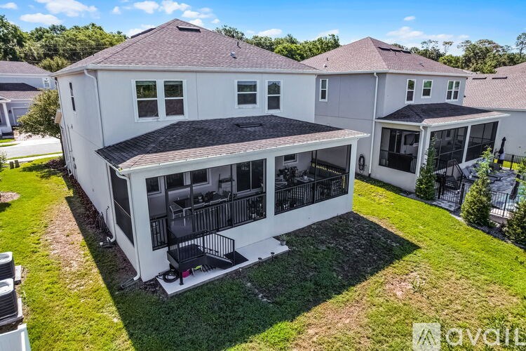 A white house with a black roof and a balcony.