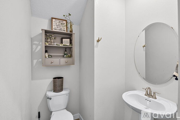 A white toilet sits next to a white sink in a small bathroom.