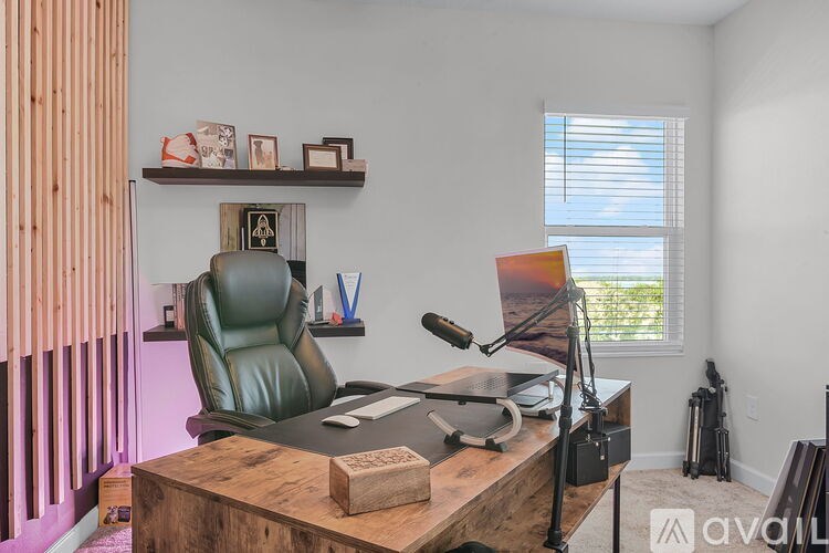 A room with a desk, chair, and a window with blinds.