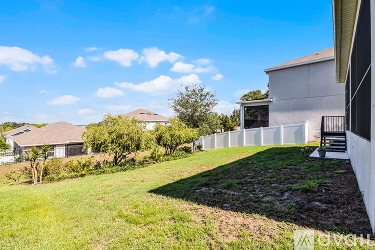 A house with a white fence and a tree in the yard.