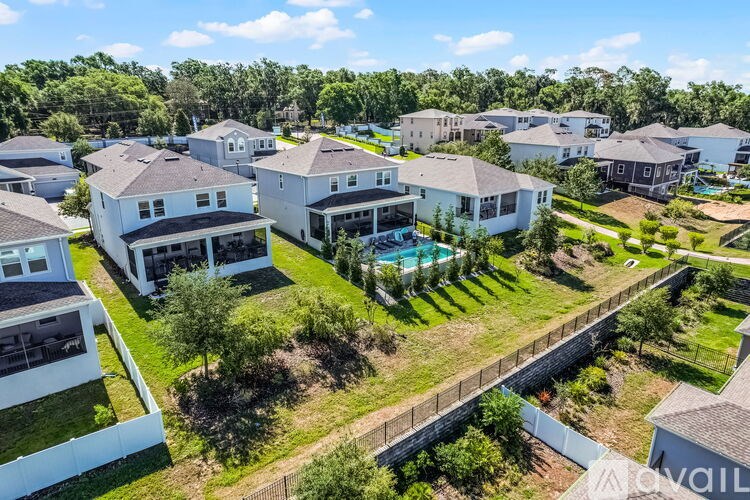 A bird's eye view of a residential area with houses and a swimming pool.