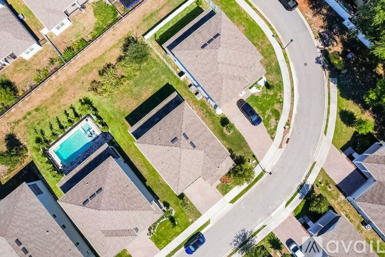 A bird's eye view of a residential area with houses and a swimming pool.
