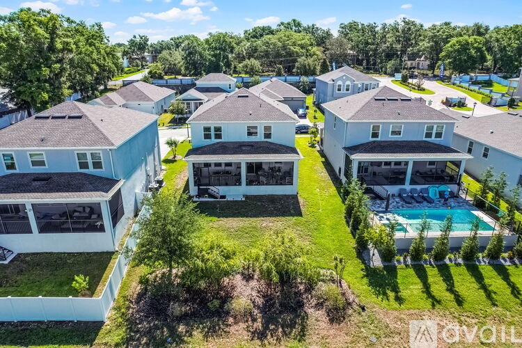 A bird's eye view of a residential area with houses and a swimming pool.