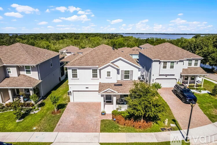 A row of houses with a car parked in front of the first one.