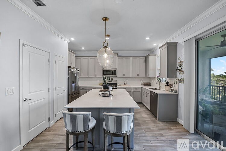 A modern kitchen with a large island and bar stools.