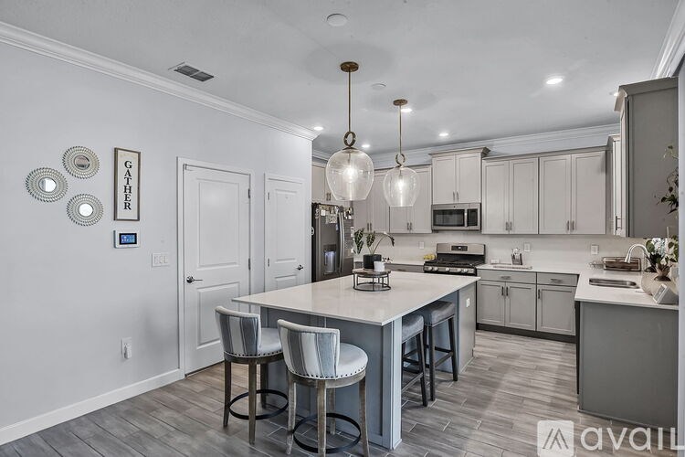 A kitchen with a table and chairs in front of it.