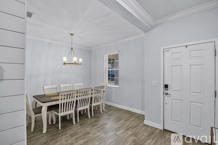 A dining room with a table and chairs.