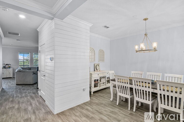 A dining room with a white table and chairs.