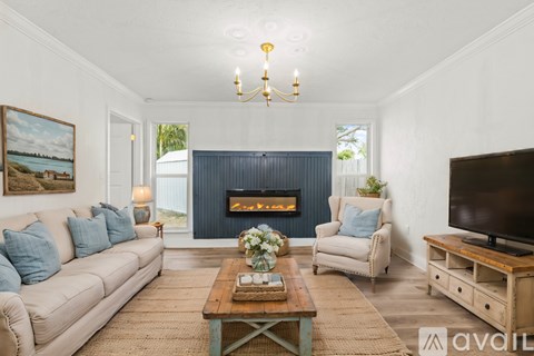 A living room with a fireplace and a painting on the wall.