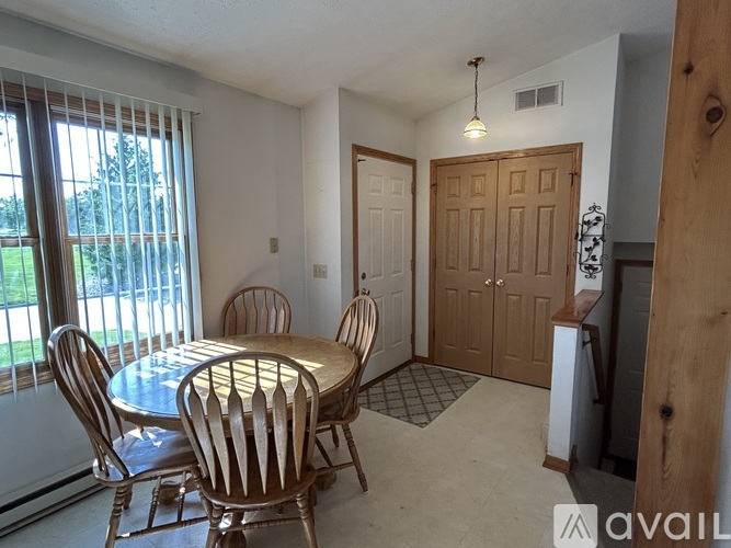 A dining room with a round table and chairs.