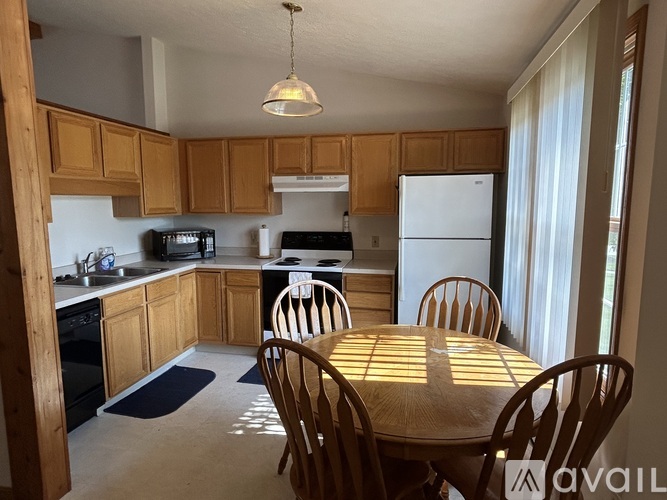 A kitchen with wooden cabinets and a white refrigerator.