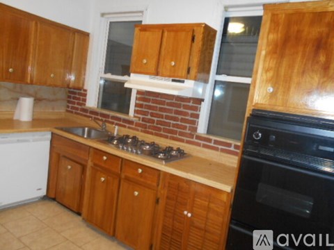 A kitchen with wooden cabinets and a brick backsplash.