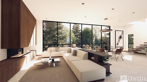 A modern living room with a large window overlooking a forest.