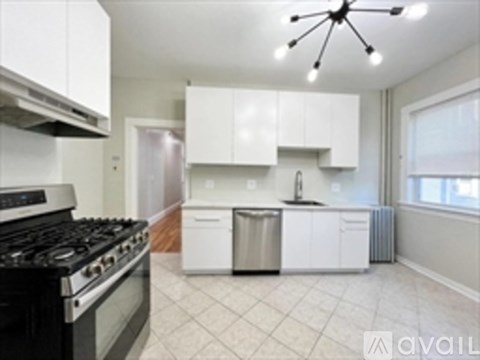 A kitchen with white cabinets and a black stove top.