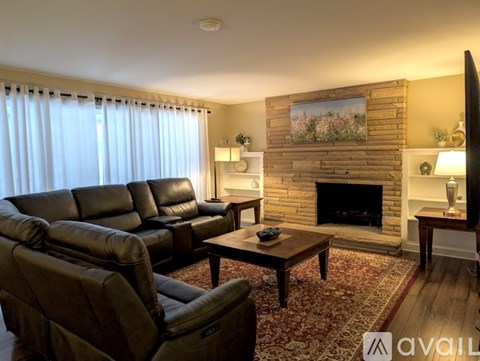 A living room with a fireplace and a painting on the wall.