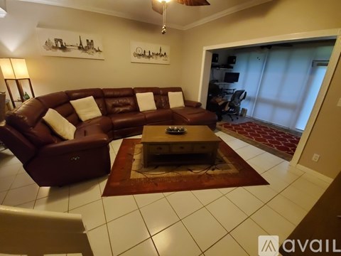 A living room with a brown couch and a coffee table.