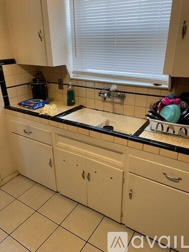 A kitchen with white cabinets and black countertops.
