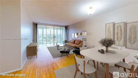 A living room with a white table and chairs, a couch, a potted plant, and a framed picture on the wall.