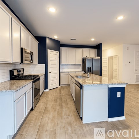 A kitchen with white cabinets and a blue accent.