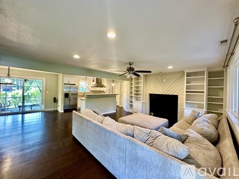 A living room with a large couch and a fireplace.